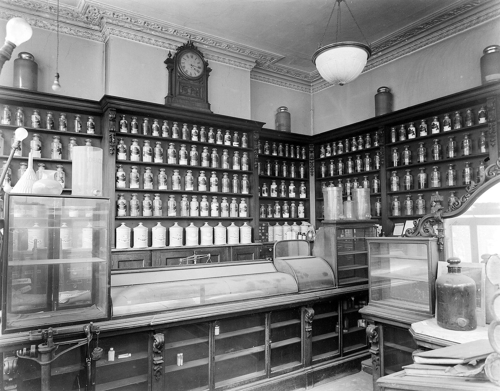 The interior of a late nineteenth-century chemist’s shop, its shelves lined with labelled apothecary jars.